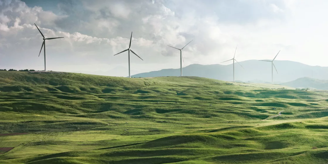 Landschaftsfoto mit Windrädern am Horizont