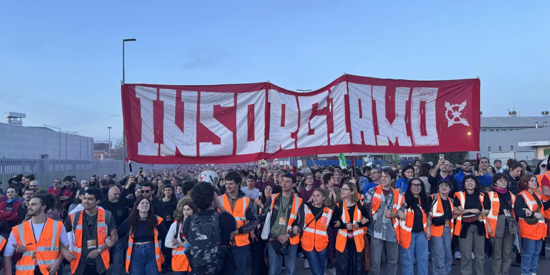 Protestierende Menschen halten ein Banner bei einer Demonstration hoch