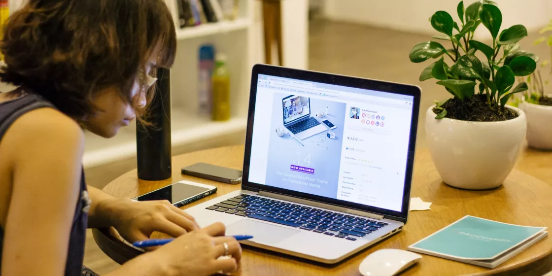 Frau sitzt am Laptop und surft im Internet.