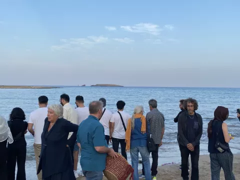 Menschen stehen am Strand und verabschieden sich