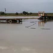 Teile eines landwirtschaftlichen Fahrzeugs stehen auf einem überschwemmten Feld