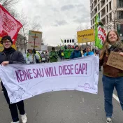 Zwei Menschen zeigen ein Banner auf einer Demonstration