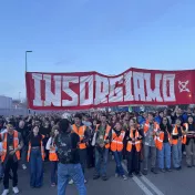 Protestierende Menschen halten ein Banner bei einer Demonstration hoch